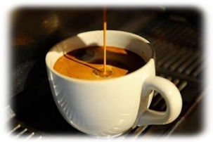 Fliessender Espresso läuft in eine Weisse Tasse